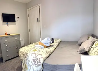 a bedroom with a bed and a dresser with a tv at Lovely Double Bedroom in Liverpool