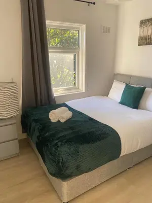 a bedroom with a bed with two towels on it at Bright 3 bedroom house with conservatory in Birkenhead