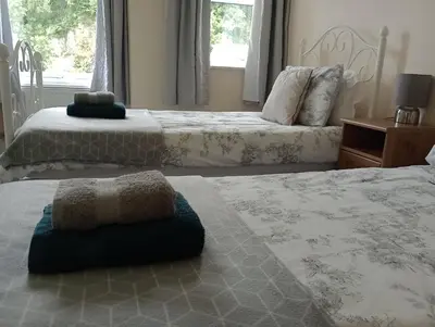 a bedroom with two beds and a window at Sunnyside Farm in Grange Over Sands