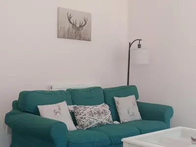 a green couch with pillows in a living room at Sunnyside Farm in Grange Over Sands