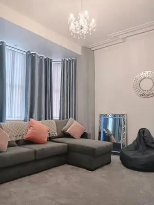 a living room with a couch and a chandelier at Luxury Town House in Blackpool