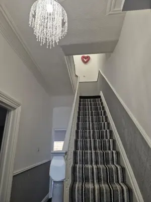 a staircase with a chandelier and a chandelier at Luxury Town House in Blackpool