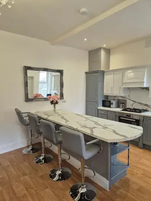 a kitchen with a large marble table and chairs at Luxury Town House in Blackpool