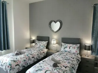 a bedroom with two beds and a heart mirror at Luxury Town House in Blackpool