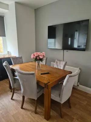 a dining room table with chairs and a vase of flowers at Luxury Town House in Blackpool
