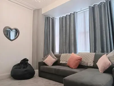 a living room with a couch and a heart mirror at Luxury Town House in Blackpool