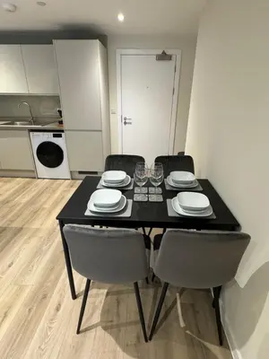 a black dining room table with chairs and a kitchen at Richmond Row by L3 Apartments in Liverpool