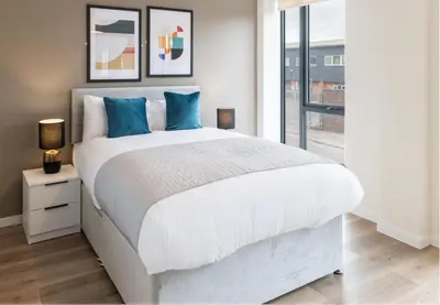 a bedroom with a large white bed with blue pillows at Richmond Row by L3 Apartments in Liverpool