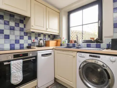 a kitchen with a washing machine and a window at Ribble Valley Cottage in Preston