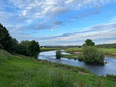 a river in the middle of a field at Ribble Valley Cottage in Preston