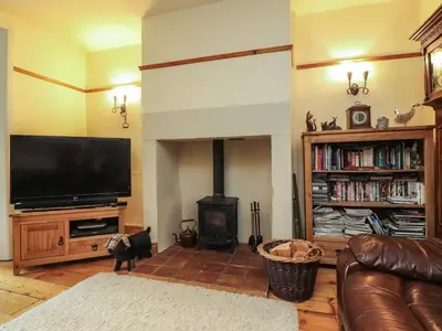 a living room with a flat screen tv and a fireplace at Ribble Valley Cottage in Preston