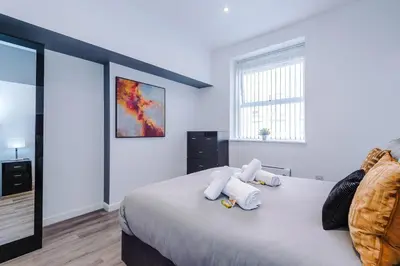 a bedroom with a bed with towels on it at The Seven Suites Liverpool in Liverpool