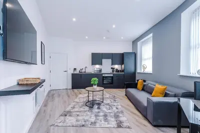 a living room with a couch and a table at The Seven Suites Liverpool in Liverpool