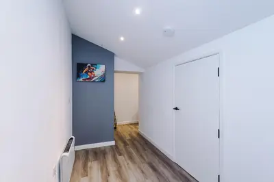 a room with white walls and a blue wall at The Seven Suites Liverpool in Liverpool