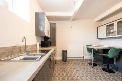 a kitchen with a sink and a table at Church Street Cottage Great Harwood in Great Harwood