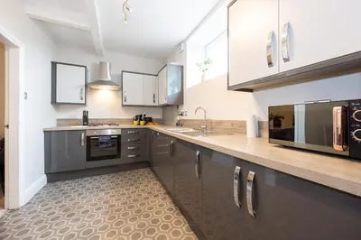 a kitchen with stainless steel appliances and wooden counter tops at Church Street Cottage Great Harwood in Great Harwood