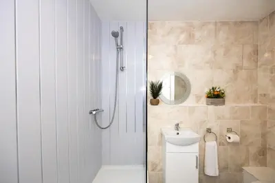 a bathroom with a shower and a toilet and a sink at Church Street Cottage Great Harwood in Great Harwood