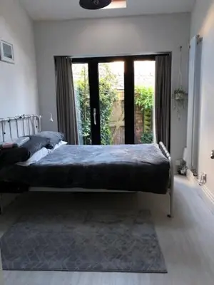 a bedroom with a bed and a large window at Beach Flat Lytham St Annes in Lytham St Annes