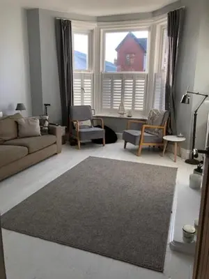a living room with a couch and chairs and a large window at Beach Flat Lytham St Annes in Lytham St Annes