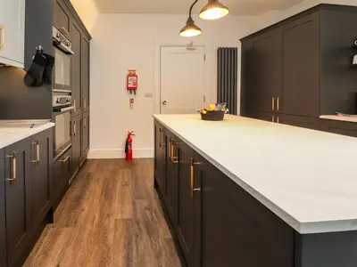 a kitchen with black cabinets and a white counter top at Eden Bay Retreat in Morecambe