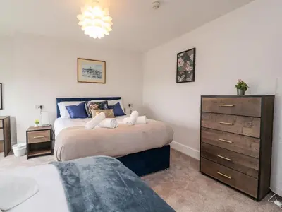 a bedroom with two beds and a dresser at Eden Bay Retreat in Morecambe