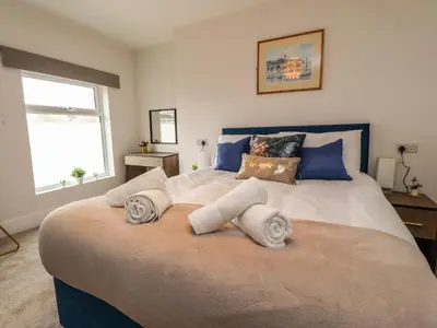 a bedroom with a large bed with towels on it at Eden Bay Retreat in Morecambe