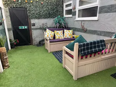 a patio with two couches sitting on the grass at Winter Gardens large modern home in Blackpool