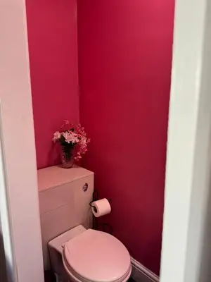 a pink bathroom with a toilet and a vase of flowers at Winter Gardens large modern home in Blackpool