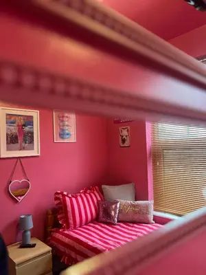 a pink room with a bed and a window at Winter Gardens large modern home in Blackpool