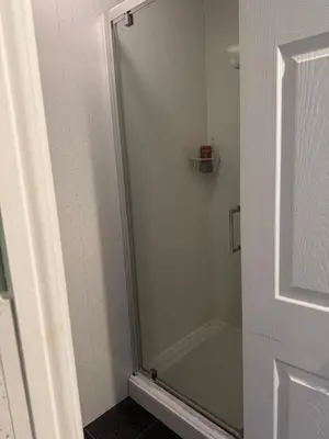 a shower with a glass door in a bathroom at Winter Gardens large modern home in Blackpool