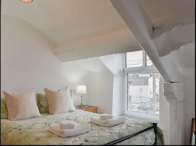 a bedroom with a bed with two pillows on it at Buxton Mews in Ulverston