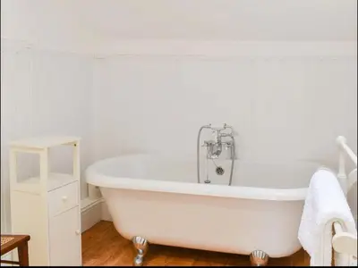 a white bath tub in a white bathroom at Buxton Mews in Ulverston