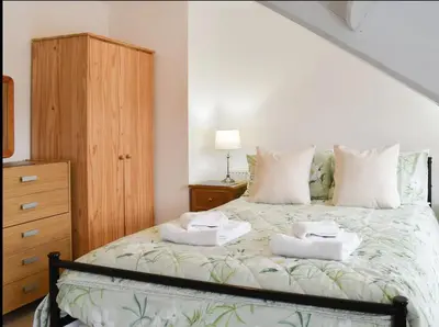 a bedroom with a bed with two towels on it at Buxton Mews in Ulverston