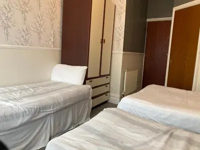 a hotel room with two beds and a cabinet at Iona Hotel in Blackpool