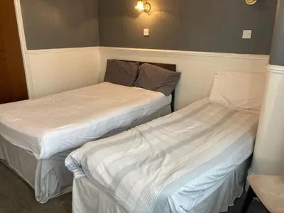 two beds in a small room withermottermott at Iona Hotel in Blackpool