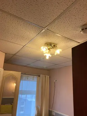 a ceiling in a room with a curtain and a window at Iona Hotel in Blackpool