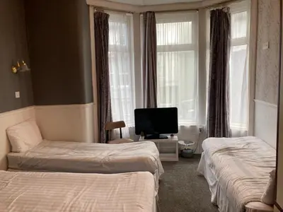 a hotel room with two beds and a television at Iona Hotel in Blackpool