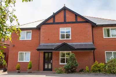 a red brick house with a black roof at The Chetwynde - Self Check In HMO in Barrow in Furness