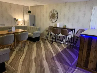 a waiting room with tables and chairs and a couch at The Fylde International Guest House in Blackpool
