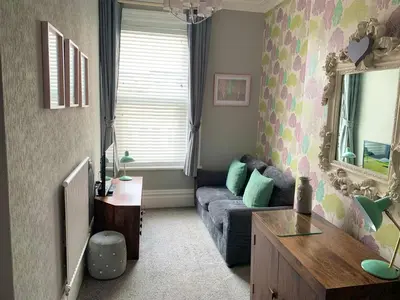 a living room with a couch and a mirror at The Fylde International Guest House in Blackpool