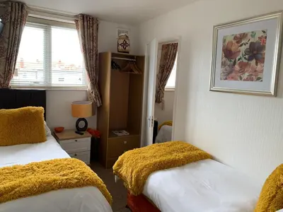 a bedroom with two beds and a window at The Fylde International Guest House in Blackpool