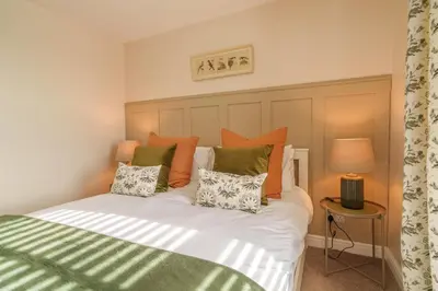 a bedroom with a bed with orange and green pillows at 40 The Gill - Ulverston Town Centre in Ulverston