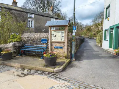 a bus stop with a bench on a street at 40 The Gill - Ulverston Town Centre in Ulverston