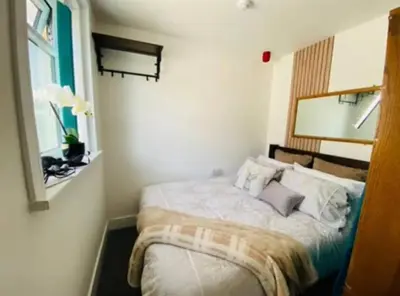 a bedroom with a bed and a window at Luminous Suites in Blackpool