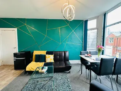 a living room with a couch and a table at Luminous Suites in Blackpool