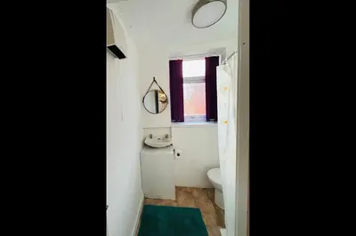 a bathroom with a sink and a toilet and a window at Luminous Suites in Blackpool