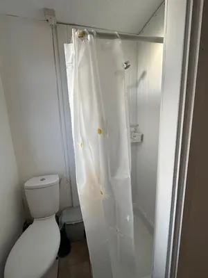 a white shower curtain in a bathroom with a toilet at Luminous Suites in Blackpool