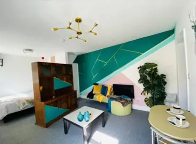 a room with a bed and a green wall at Luminous Suites in Blackpool