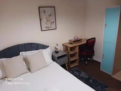 a bedroom with a bed and a desk and a chair at POTTERS LOGDE LIVERPOOL by Edl Ventures Ltd in Liverpool