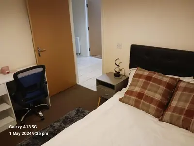 a bedroom with a bed and a desk and a chair at POTTERS LOGDE LIVERPOOL by Edl Ventures Ltd in Liverpool